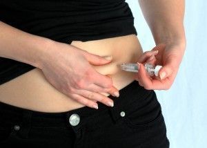 una mujer se pincha heparina en el abdomen