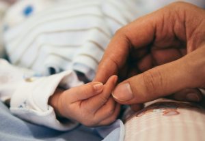 mano de un recién nacido y de una adulta